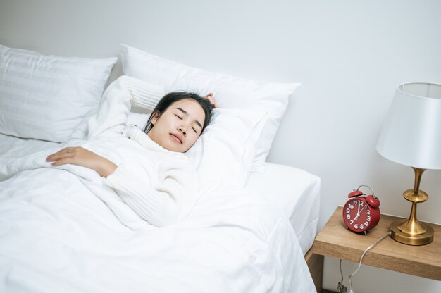 A woman wearing a white shirt to sleep.