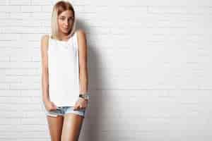 Free photo woman wearing white tshirt against brick wall