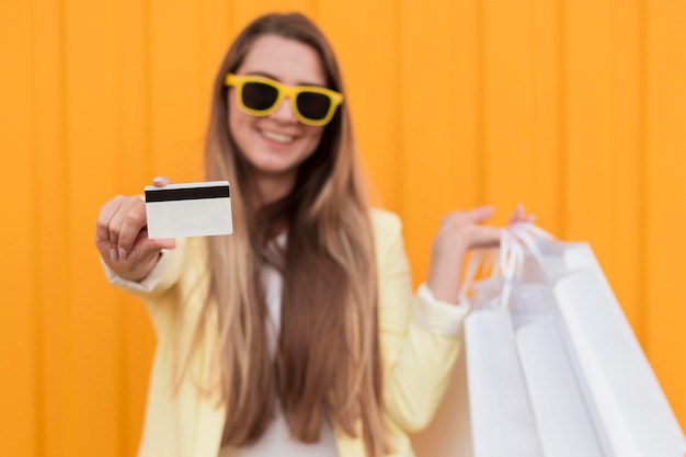 Woman wearing yellow clothes holding shopping card