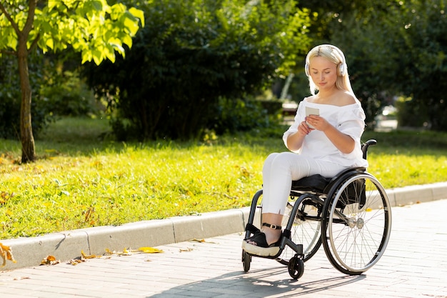 Woman in wheelchair listening to music outside