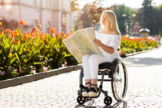 Woman in wheelchair looking at map outdoors