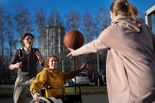 Woman in wheelchair playing basketball side view