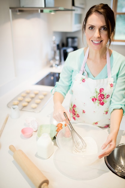 Woman whisking flour in bowl