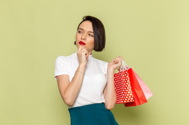 woman in white blouse and green skirt holding shopping packages