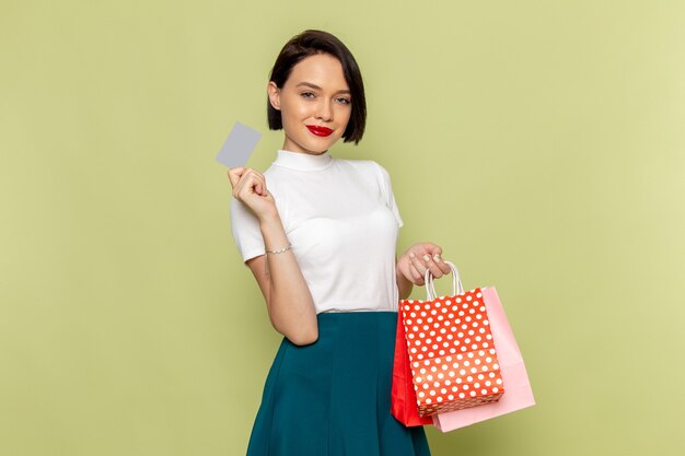 woman in white blouse and green skirt holding shopping packages 