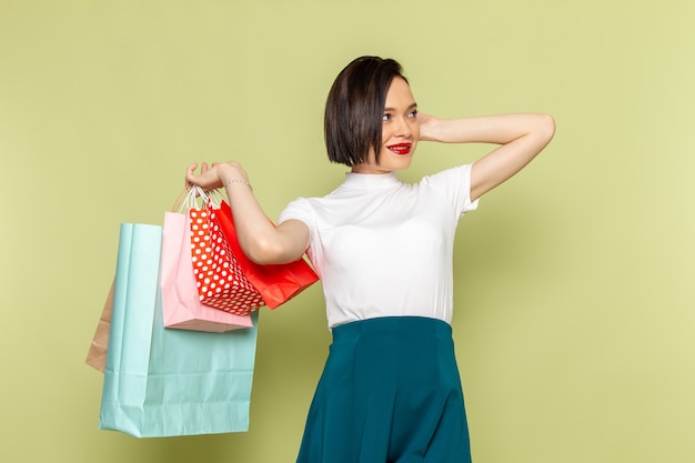 woman in white blouse and green skirt holding shopping packages 