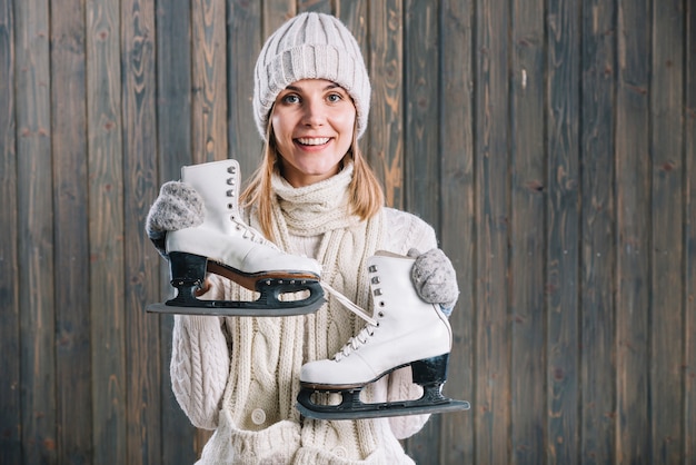 Free photo woman in white cap holding skates