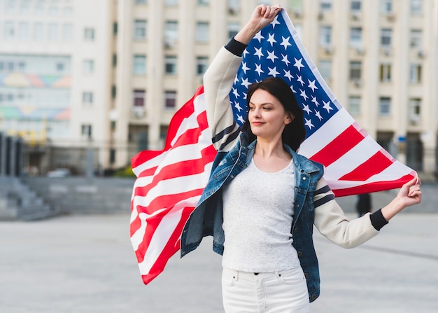 Woman in white clothes with American flag on street 