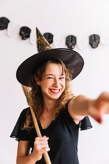 Free photo woman in witch costume with black broom