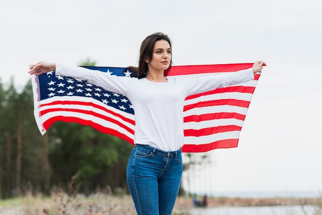 Free photo woman with american flag by the sea