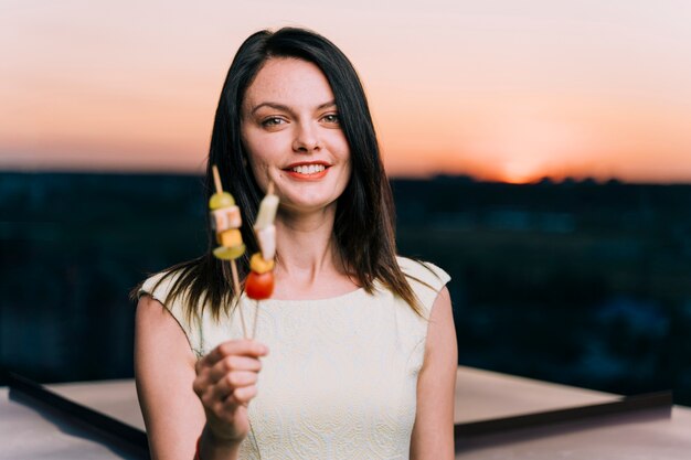 Woman with appetizers on rooftop at dawn