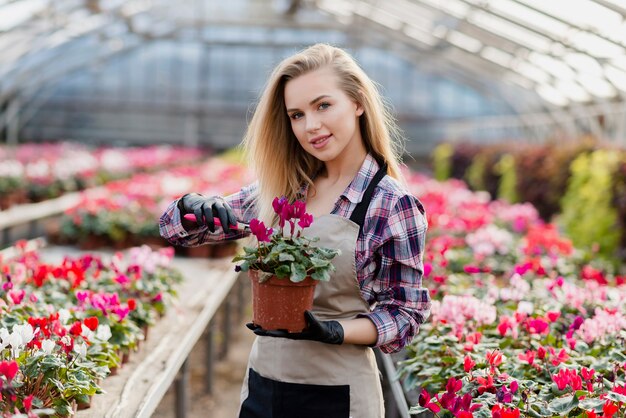 Woman with apron holding flower pot