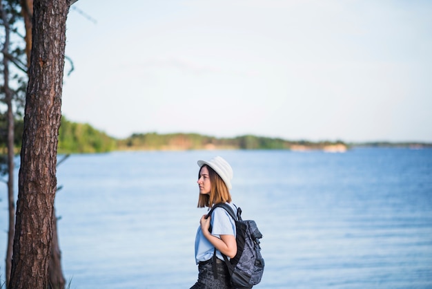 Free photo woman with backpack near lake