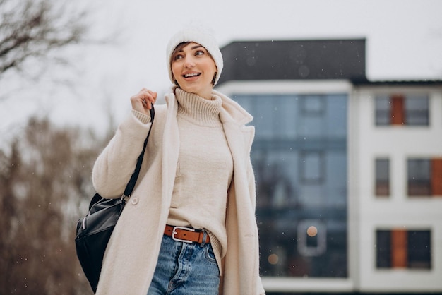 Free Photo woman with bag wearing winter coat walking in the street