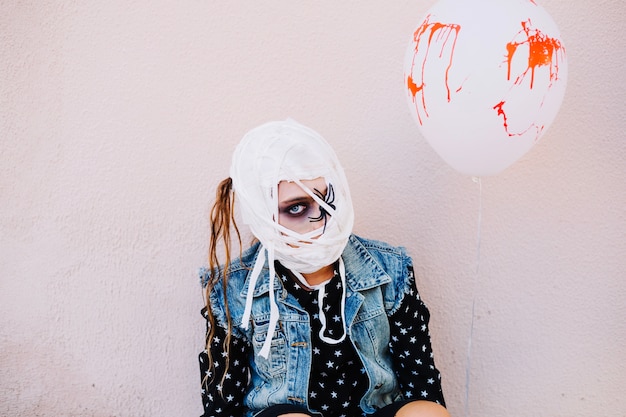 Woman with bandage on face and balloon