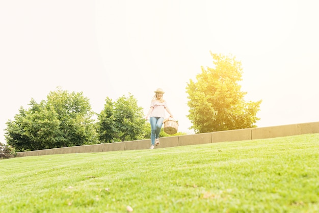 Woman with basket waking in park