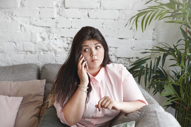 A woman with beautiful body is posing on the couch