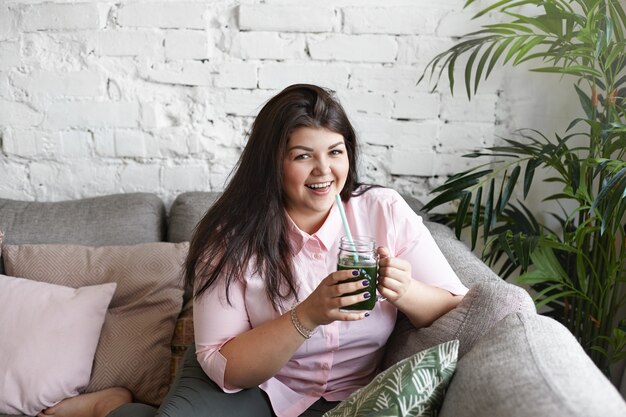 A woman with beautiful body is posing on the couch