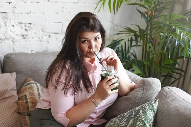 A woman with beautiful body is posing on the couch