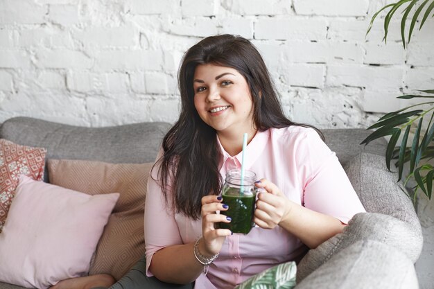 A woman with beautiful body is posing on the couch