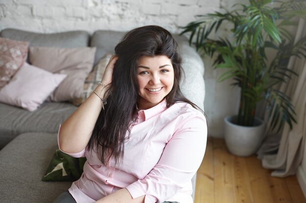 A woman with beautiful body is posing on the couch