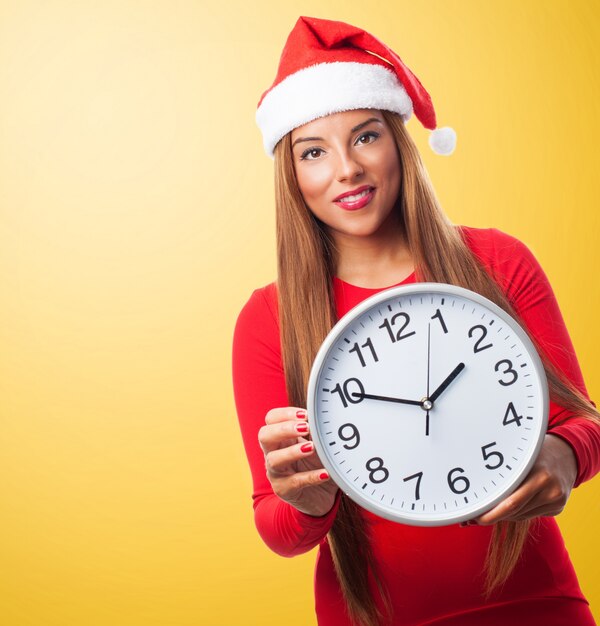 Woman with a big clock and santa's hat