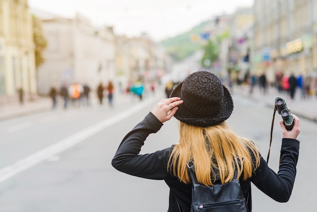 Free photo woman with binoculars on street