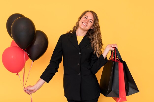 Woman with black and red bags with balloons