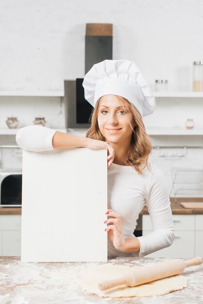 Woman with blank paper in kitchen