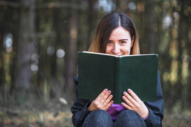 Woman with book looking at camera