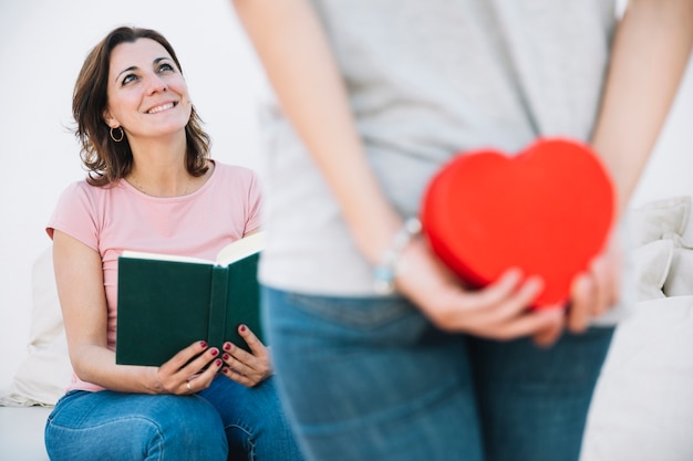 Free photo woman with book looking at woman making surprise