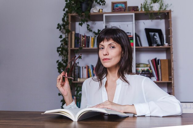 Woman with book and reading glasses