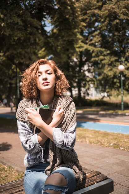 Free photo woman with books sitting on bench