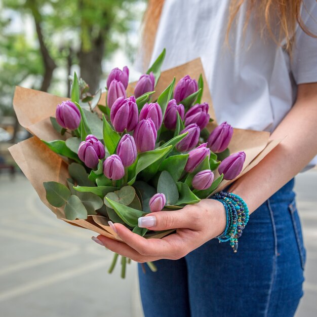 Woman with a bouquet of violet tulips.