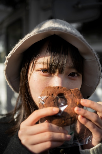 Woman with bucket hat holding pretzel