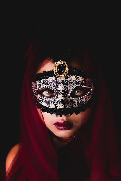 Free photo woman with a carnival mask on a dark background