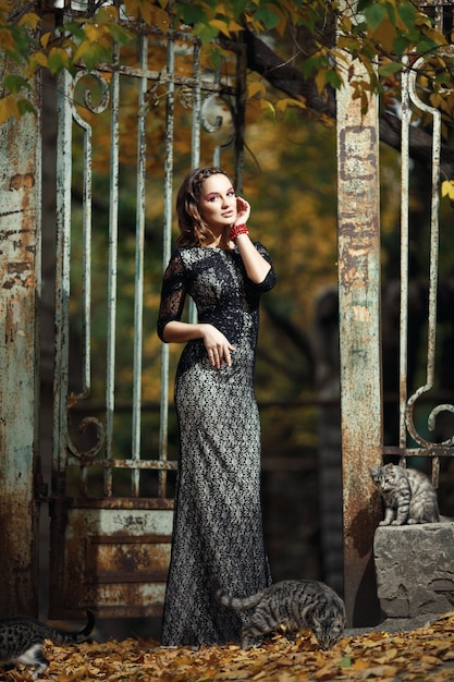 Free Photo woman with cats and a rusty iron fence