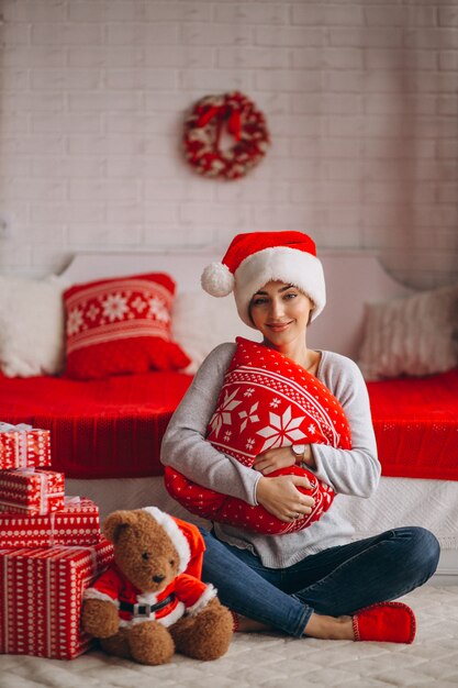 Woman with Christmas presents by Christmas tree