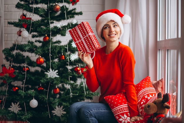 Woman with Christmas presents by Christmas tree