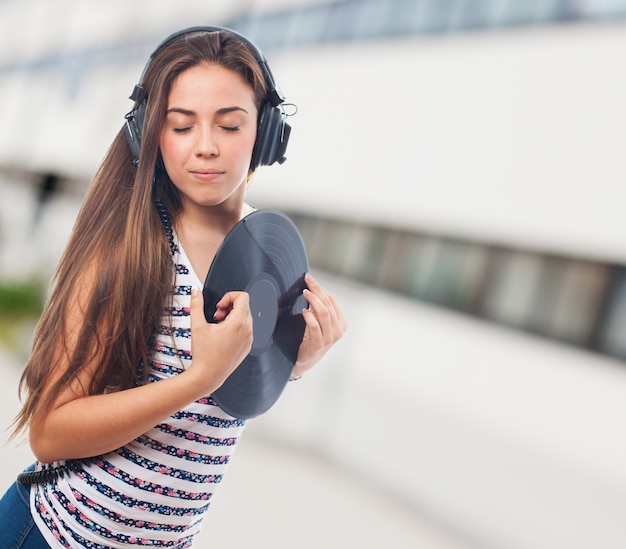 Woman with closed eyes and a vinyl record