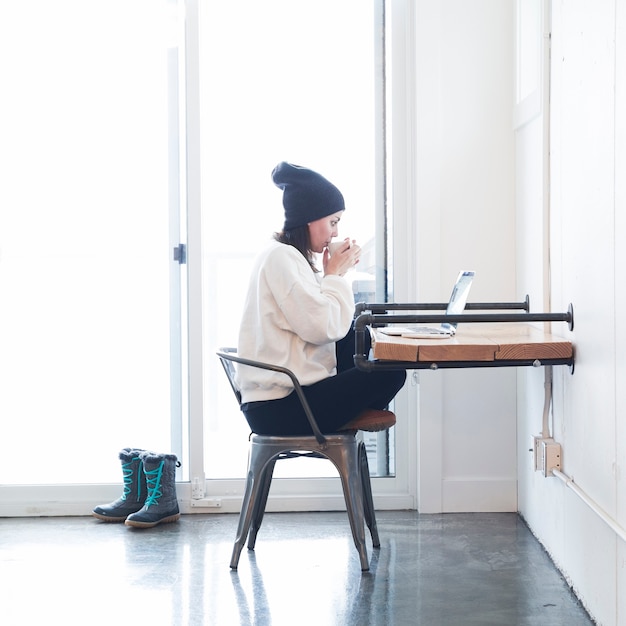 Woman with coffee and laptop at table