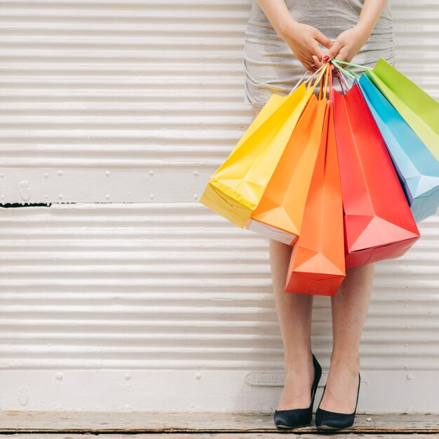 Woman with colorful bags at wall