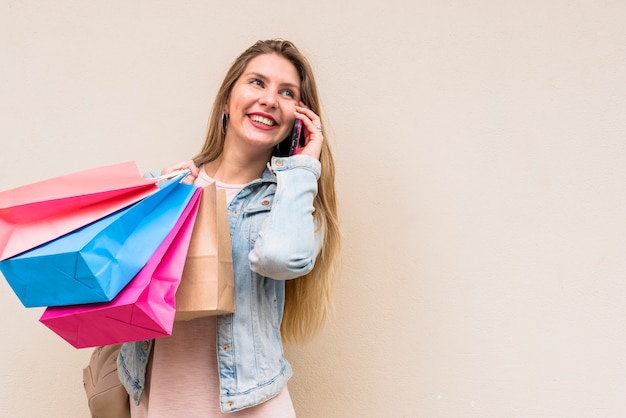 Free Photo woman with colourful shopping bags talking by phone