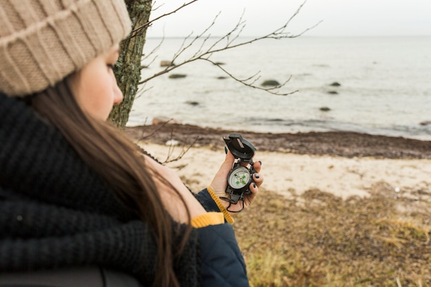 Free photo woman with compass on shore