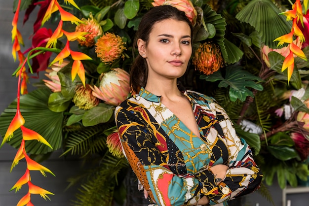 Woman with crossed arms standing in green house 