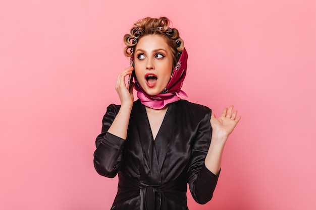 Free photo woman with curlers dressed in silk robe and scarf talking on phone