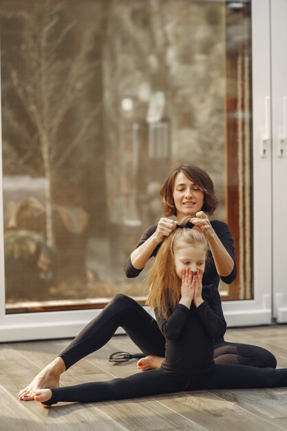 Woman with daughter is engaged in gymnastics