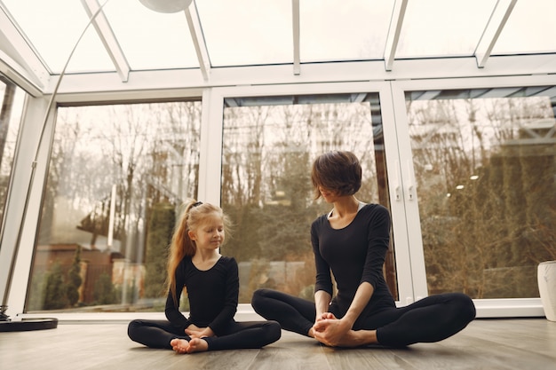 Free photo woman with daughter is engaged in gymnastics