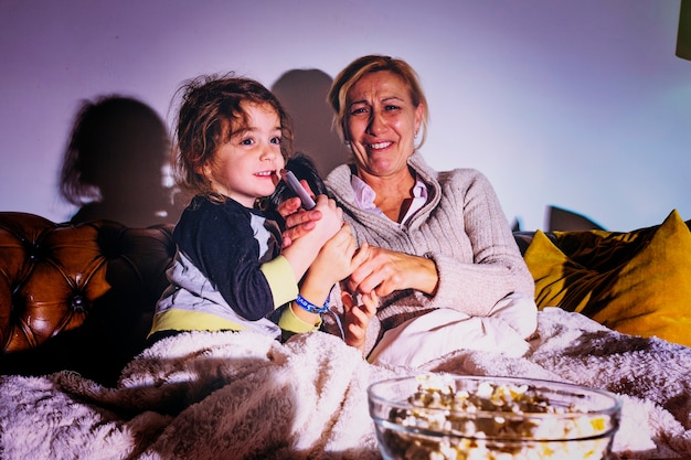 Woman with daughters watching TV in dark