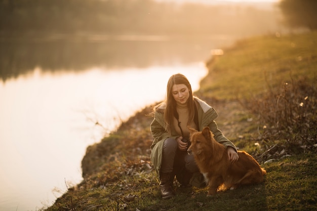 Free Photo woman with dog holding camera